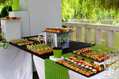 Salle de bain moderne avec carrelage gris, lavabo, toilettes et fenêtre laissant entrer la lumière naturelle.