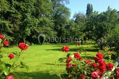 Salle de bain moderne avec carrelage gris, lavabo, toilettes et fenêtre laissant entrer la lumière naturelle.