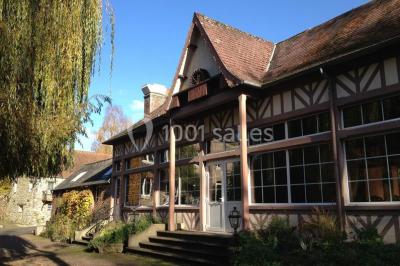 Salle de bain moderne avec carrelage gris, lavabo, toilettes et fenêtre laissant entrer la lumière naturelle.