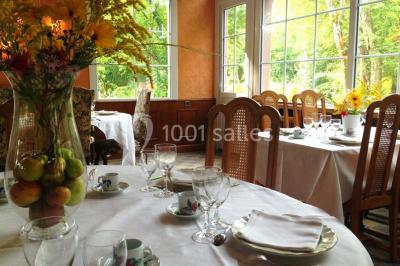 Salle de bain moderne avec carrelage gris, lavabo, toilettes et fenêtre laissant entrer la lumière naturelle.