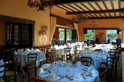 Salle de bain moderne avec carrelage gris, lavabo, toilettes et fenêtre laissant entrer la lumière naturelle.