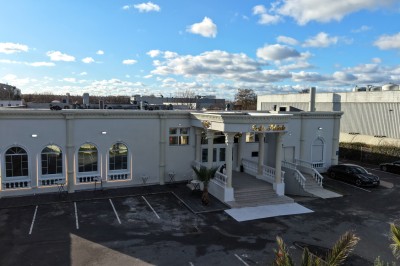 Miniature Location salle Stains (Seine-Saint-Denis) - Salle Mélodie #10 Façade d'un bâtiment blanc avec des arches vitrées, un escalier central et un parking vide à l'avant.