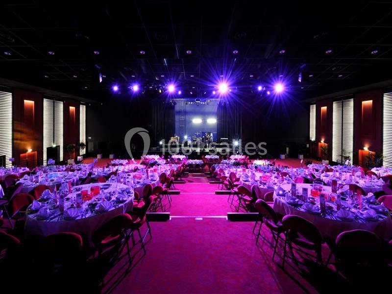 Location salle La Grande-Motte (Hérault) - Pasino de la Grande Motte #2 Salle de réception avec tables rondes dressées et éclairage violet, scène en fond avec équipement musical.
