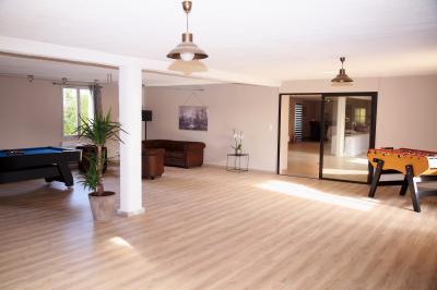 Chambre lumineuse avec lit double, armoire, téléviseur sur table et fenêtre donnant sur un extérieur verdoyant.