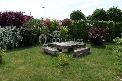 Chambre lumineuse avec lit double, armoire, téléviseur sur table et fenêtre donnant sur un extérieur verdoyant.