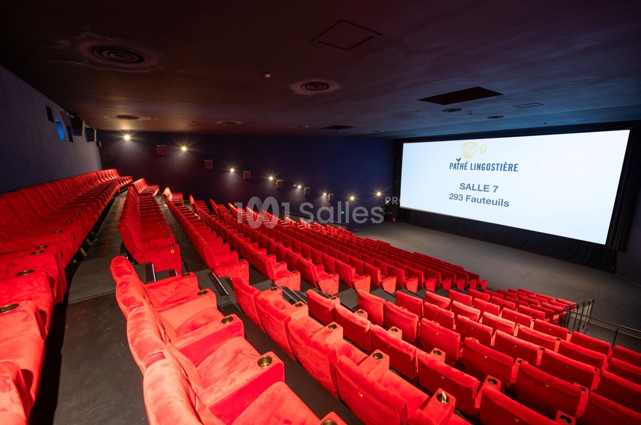 Salle de cinéma avec rangées de fauteuils rouges vides et écran affichant ’Pathé Lingostière, Salle 7, 293 fauteuils’.