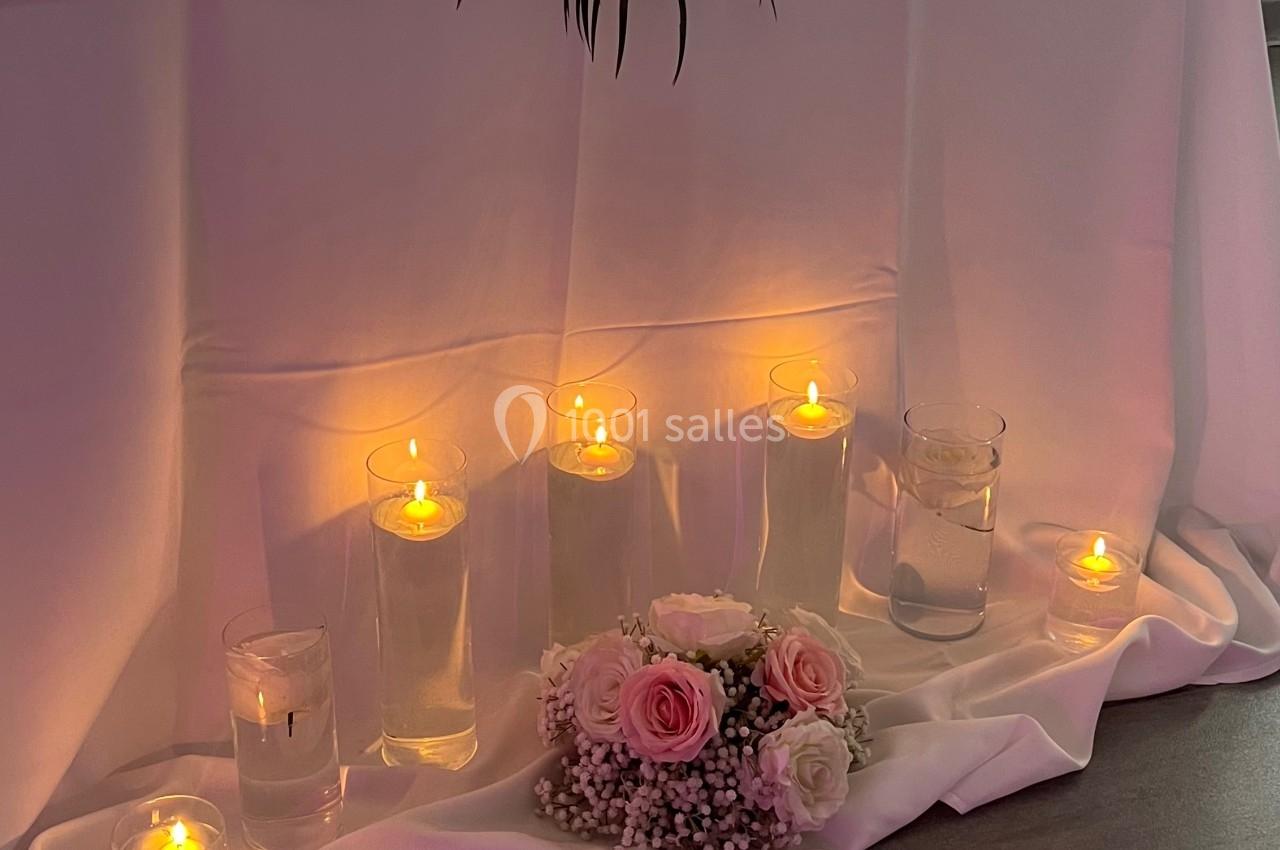 Location salle Beauchamp (Val-d'Oise) - Les Salons Beauchamp #20 Table décorée pour un événement avec fleurs roses et blanches, bougies allumées et voilage en arrière-plan.