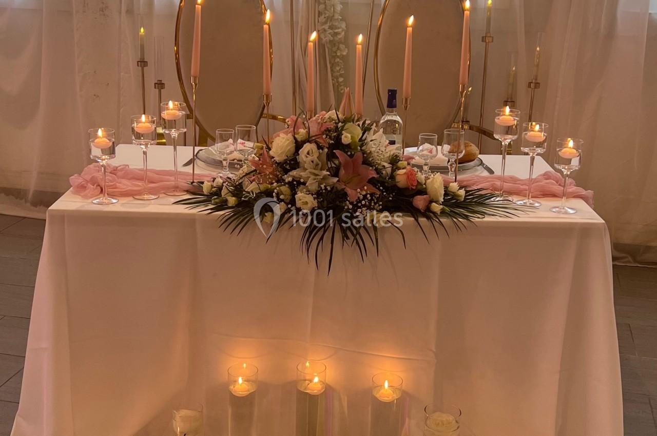 Location salle Beauchamp (Val-d'Oise) - Les Salons Beauchamp #19 Table décorée pour un mariage avec bougies, fleurs roses et blanches, et deux miroirs ovales en arrière-plan.