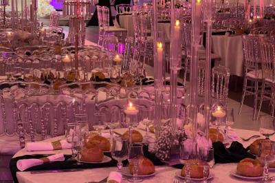 Miniature Location salle Beauchamp (Val-d'Oise) - Les Salons Beauchamp #36 Salle de réception élégante avec tables décorées de fleurs blanches, chaises transparentes et éclairage tamisé.