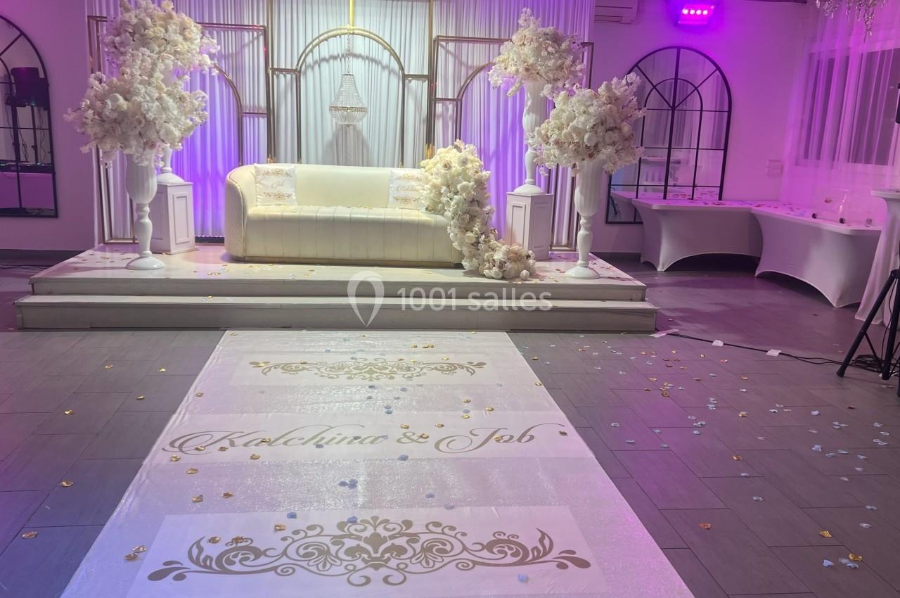 Location salle Beauchamp (Val-d'Oise) - Les Salons Beauchamp #17 Salle de réception décorée pour un mariage, avec un canapé blanc, des fleurs blanches et une allée personnalisée.