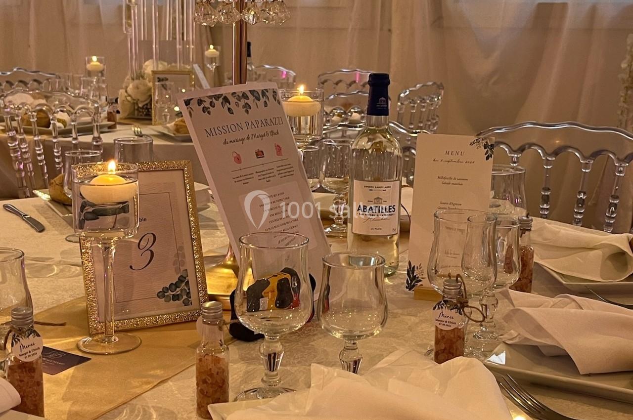 Location salle Beauchamp (Val-d'Oise) - Les Salons Beauchamp #41 Table élégamment dressée pour un événement, avec décorations, chandeliers, menus et pain sur une assiette blanche.