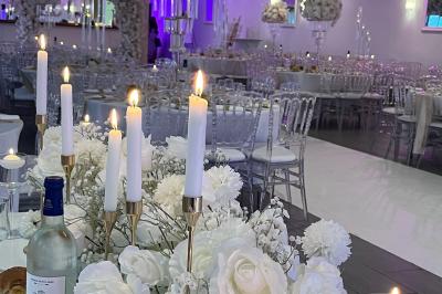 Miniature Location salle Beauchamp (Val-d'Oise) - Les Salons Beauchamp #34 Salle de réception élégante avec tables décorées de fleurs blanches, chaises transparentes et éclairage tamisé.