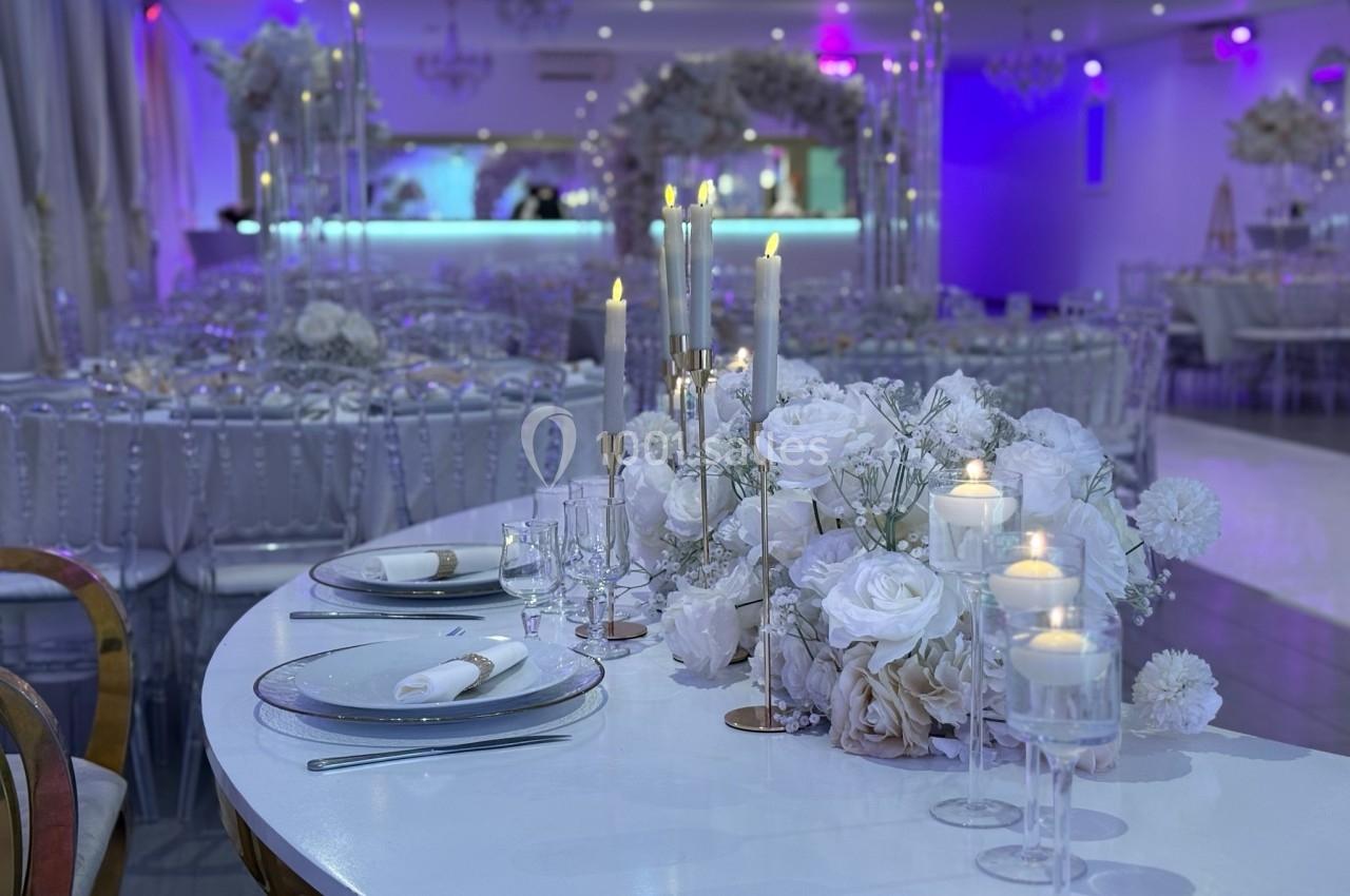 Location salle Beauchamp (Val-d'Oise) - Les Salons Beauchamp #16 Salle de réception décorée avec des fleurs blanches, des chandeliers et des tables élégamment dressées.