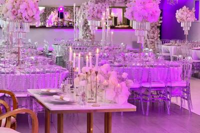 Miniature Location salle Beauchamp (Val-d'Oise) - Les Salons Beauchamp #3 Salle de réception élégante avec tables décorées de fleurs blanches, chaises transparentes et éclairage tamisé.