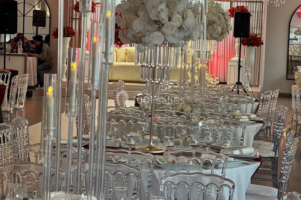 Location salle Beauchamp (Val-d'Oise) - Les Salons Beauchamp #44 Salle de réception élégante avec tables dressées, chaises transparentes et décorations florales blanches et rouges.