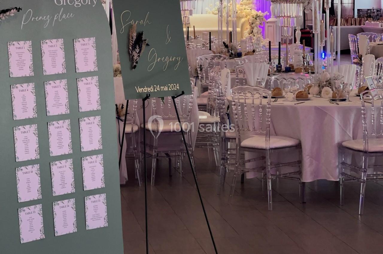 Location salle Beauchamp (Val-d'Oise) - Les Salons Beauchamp #39 Salle de réception décorée pour un mariage avec panneaux de bienvenue et plan de table, tables dressées et fleurs blanches.