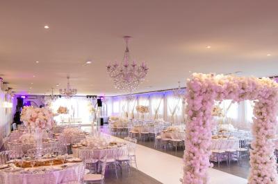 Miniature Location salle Beauchamp (Val-d'Oise) - Les Salons Beauchamp #48 Salle de réception élégante avec tables décorées de fleurs blanches, chaises transparentes et éclairage tamisé.