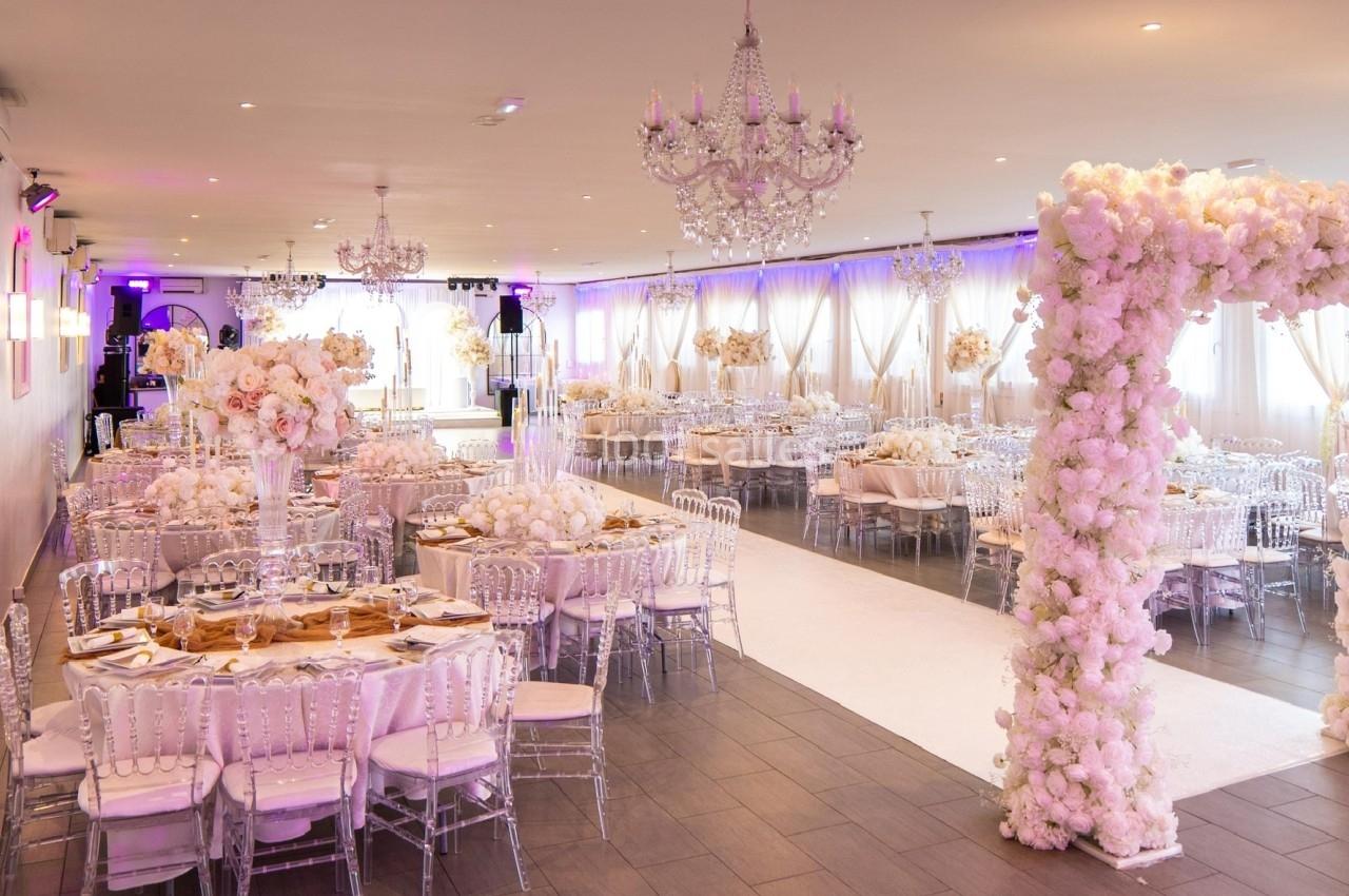 Location salle Beauchamp (Val-d'Oise) - Les Salons Beauchamp #2 Salle de réception élégante décorée de fleurs blanches, avec tables dressées et chaises transparentes.