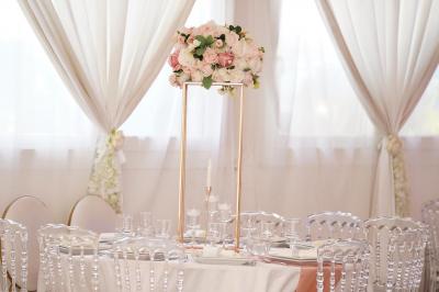 Miniature CENTRE DE TABLE Salle de réception élégante avec tables décorées de fleurs blanches, chaises transparentes et éclairage tamisé.