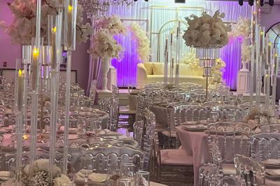 Miniature DECO 2024 2025 Salle de réception élégante avec tables décorées de fleurs blanches, chaises transparentes et éclairage tamisé.