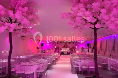 Miniature DECO ARBRE CERISIER Salle de réception élégante avec tables décorées de fleurs blanches, chaises transparentes et éclairage tamisé.