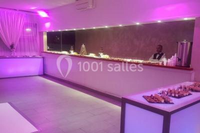 Miniature NOTRE BAR Salle de réception élégante avec tables décorées de fleurs blanches, chaises transparentes et éclairage tamisé.