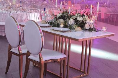 Miniature TABLE D HONNEUR COMPOS FLORALE Salle de réception élégante avec tables décorées de fleurs blanches, chaises transparentes et éclairage tamisé.