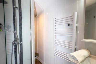 Miniature Location salle Saint-Aignan-de-Cramesnil (Calvados) - La Jalousie #26 Salle de bain moderne avec douche à l'italienne, lavabo avec miroir, radiateur sèche-serviettes et carrelage clair.