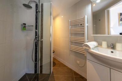 Miniature Location salle Saint-Aignan-de-Cramesnil (Calvados) - La Jalousie #27 Salle de bain moderne avec douche à l'italienne, lavabo avec miroir, radiateur sèche-serviettes et carrelage clair.