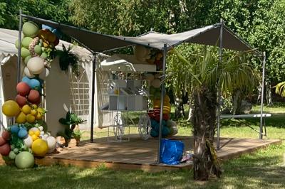 Buffet en plein air avec une variété de plats et boissons, installé sous une tente lors d'un événement convivial.