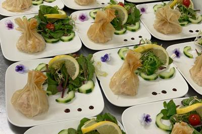 Buffet en plein air avec une variété de plats et boissons, installé sous une tente lors d'un événement convivial.