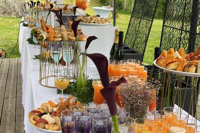 Buffet en plein air avec une variété de plats et boissons, installé sous une tente lors d'un événement convivial.