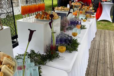 Buffet en plein air avec une variété de plats et boissons, installé sous une tente lors d'un événement convivial.
