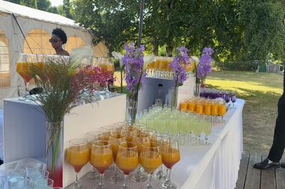 Buffet en plein air avec une variété de plats et boissons, installé sous une tente lors d'un événement convivial.