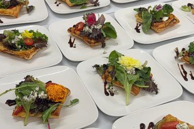 Buffet en plein air avec une variété de plats et boissons, installé sous une tente lors d'un événement convivial.