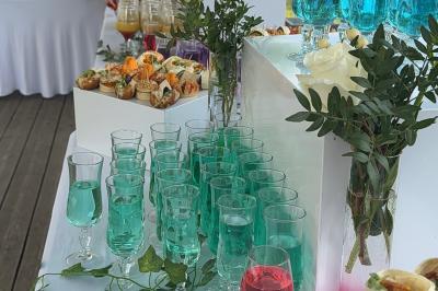 Buffet en plein air avec une variété de plats et boissons, installé sous une tente lors d'un événement convivial.