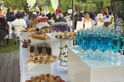 Buffet en plein air avec une variété de plats et boissons, installé sous une tente lors d'un événement convivial.