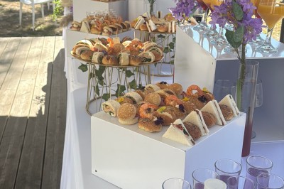 Buffet en plein air avec une variété de plats et boissons, installé sous une tente lors d'un événement convivial.