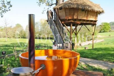 Miniature Location salle Vignieu (Isère) - Domaine de Suzel #22 Chambre avec lit rond, couverture rouge, pétales de rose, lampe de chevet et plafond en bois avec suspension plumeuse.