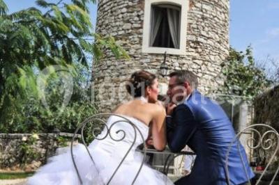 Miniature Location salle Vignieu (Isère) - Domaine de Suzel #13 Chambre avec lit rond, couverture rouge, pétales de rose, lampe de chevet et plafond en bois avec suspension plumeuse.