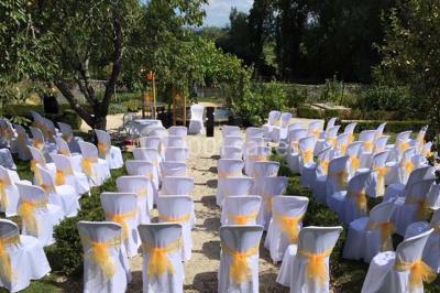 Miniature Location salle Vignieu (Isère) - Domaine de Suzel #14 Chambre avec lit rond, couverture rouge, pétales de rose, lampe de chevet et plafond en bois avec suspension plumeuse.