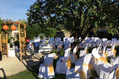 Miniature Location salle Vignieu (Isère) - Domaine de Suzel #12 Chambre avec lit rond, couverture rouge, pétales de rose, lampe de chevet et plafond en bois avec suspension plumeuse.