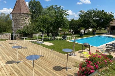 Miniature Location salle Vignieu (Isère) - Domaine de Suzel #24 Chambre avec lit rond, couverture rouge, pétales de rose, lampe de chevet et plafond en bois avec suspension plumeuse.