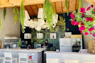 Miniature Location salle Vignieu (Isère) - Domaine de Suzel #26 Chambre avec lit rond, couverture rouge, pétales de rose, lampe de chevet et plafond en bois avec suspension plumeuse.