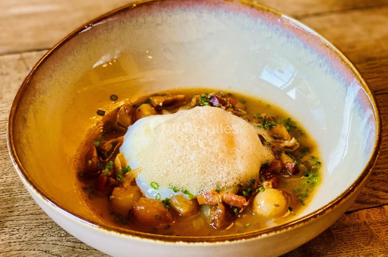 Location salle Vignieu (Isère) - Domaine de Suzel #8 Assiette creuse contenant un plat composé d'un œuf poché, mousse légère, légumes et garniture dans un bouillon.