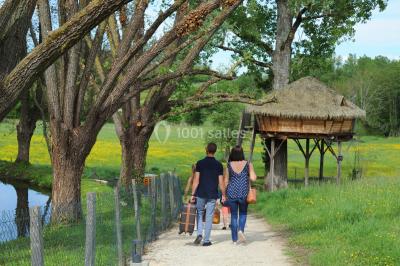 Miniature Location salle Vignieu (Isère) - Domaine de Suzel #28 Chambre avec lit rond, couverture rouge, pétales de rose, lampe de chevet et plafond en bois avec suspension plumeuse.