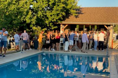 Miniature Location salle Vignieu (Isère) - Domaine de Suzel #34 Chambre avec lit rond, couverture rouge, pétales de rose, lampe de chevet et plafond en bois avec suspension plumeuse.