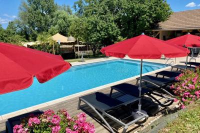 Miniature Location salle Vignieu (Isère) - Domaine de Suzel #36 Chambre avec lit rond, couverture rouge, pétales de rose, lampe de chevet et plafond en bois avec suspension plumeuse.