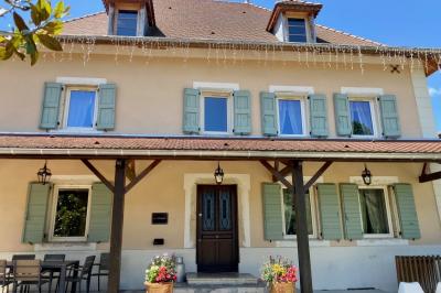 Miniature Location salle Vignieu (Isère) - Domaine de Suzel #40 Chambre avec lit rond, couverture rouge, pétales de rose, lampe de chevet et plafond en bois avec suspension plumeuse.