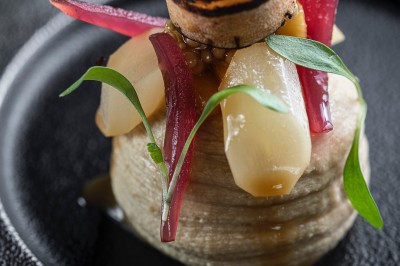 Miniature Location salle Vignieu (Isère) - Domaine de Suzel #43 Chambre avec lit rond, couverture rouge, pétales de rose, lampe de chevet et plafond en bois avec suspension plumeuse.